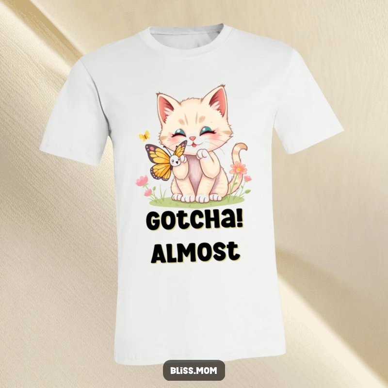 Funny kawaii kitten mid-pounce, batting playfully at a fluttering butterfly on a soft cotton t-shirt, expressing joyful mischief.